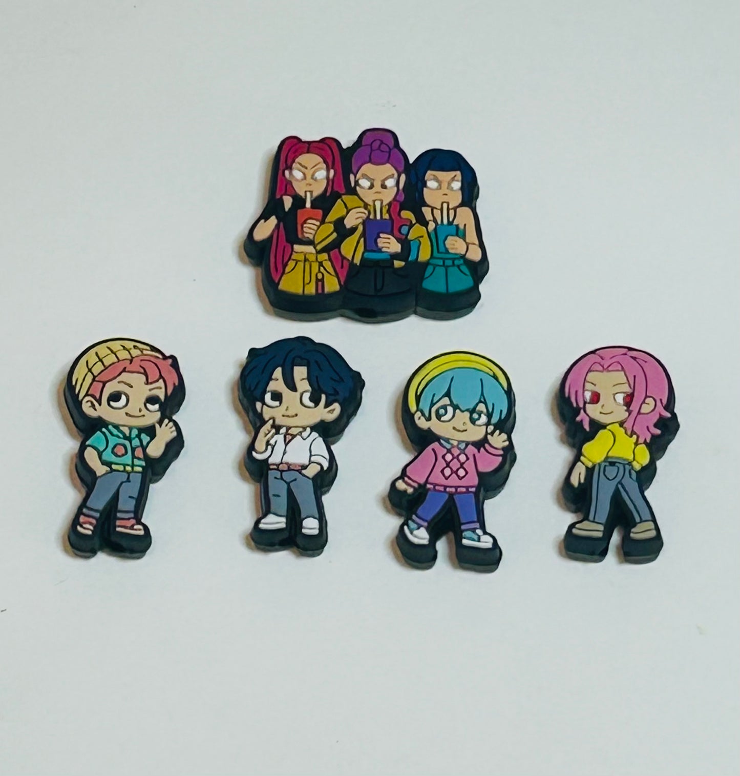 Set of five colorful anime-style character pins on a white background